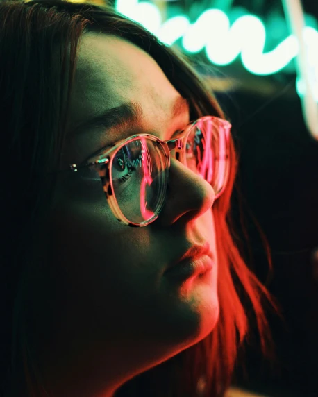 a close up of a person wearing glasses, inspired by Elsa Bleda, trending on pexels, colorful neon signs, queer woman, looking out, bisexual lighting