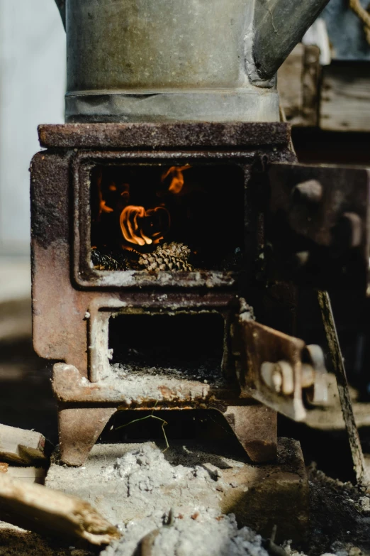 a stove with a pot on top of it, by Elsa Bleda, unsplash contest winner, renaissance, smouldering charred timber, small manufacture, vehicle, dynamic closeup