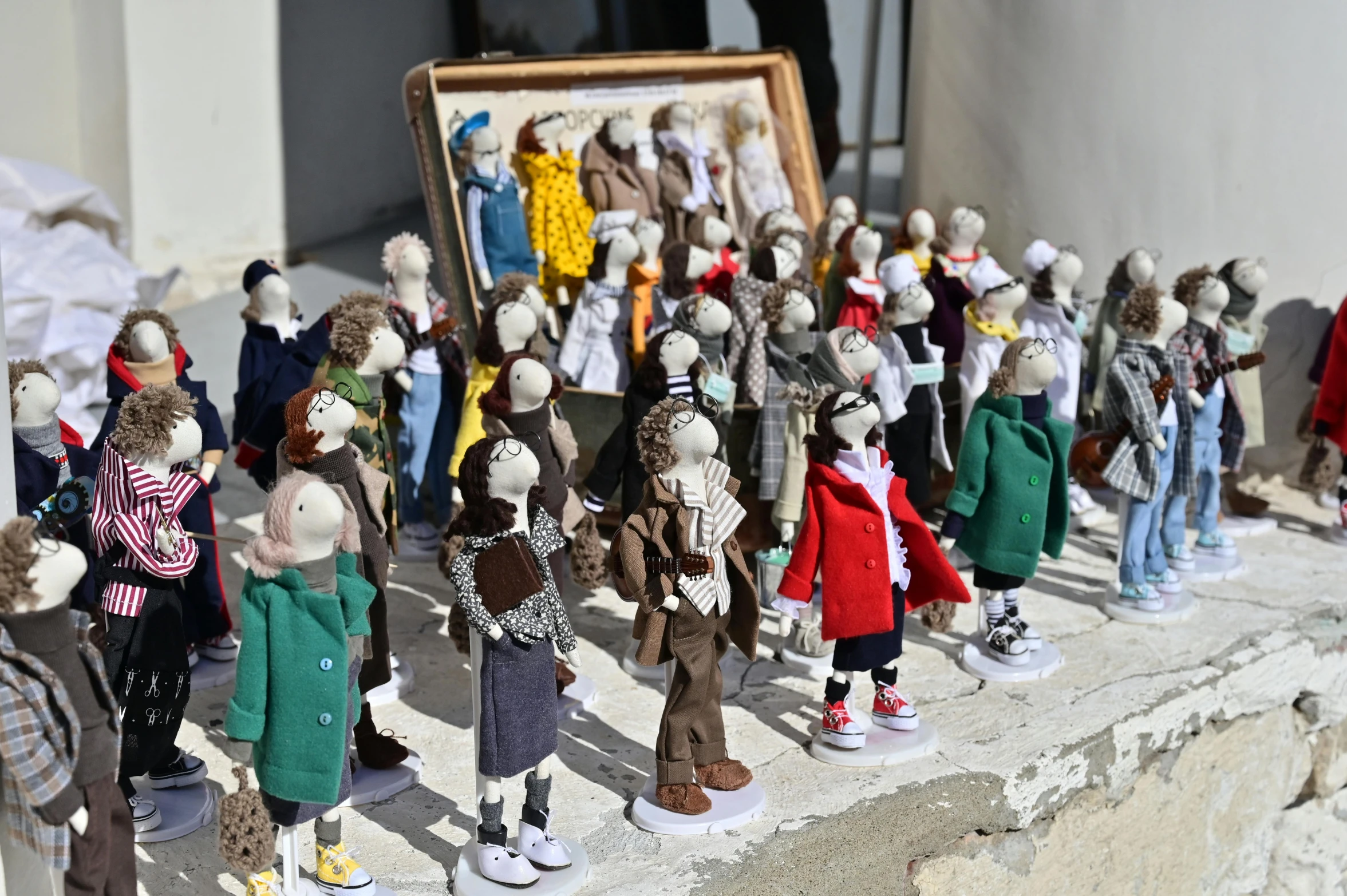 a group of figurines sitting on top of a table, by Sylvia Wishart, unsplash, naive art, standing in street, made out of wool, framed, brutalist fashion show