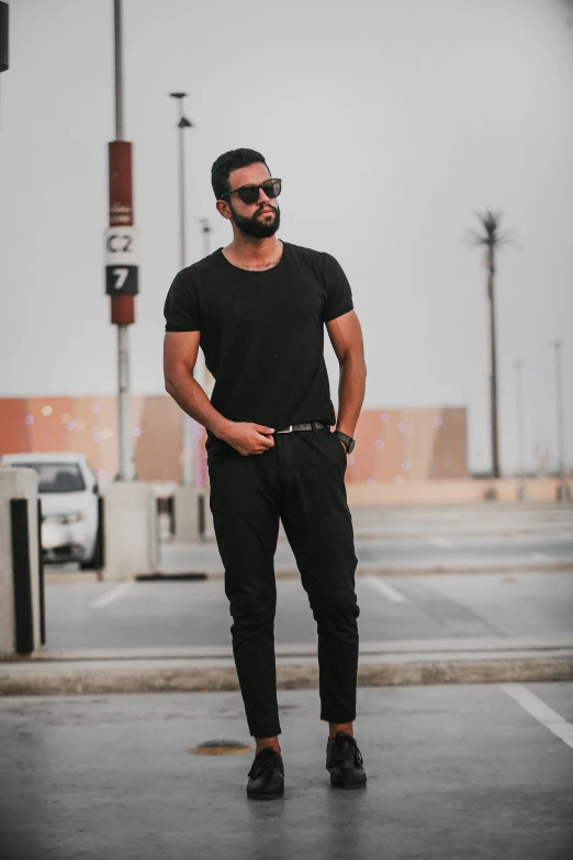 a man standing in the middle of a parking lot, by Ahmed Yacoubi, wearing a black!! t - shirt, matte black pants, arabia, profile image