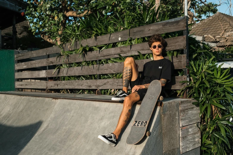 a man sitting on top of a skateboard ramp, pexels contest winner, bella poarch, casual black clothing, zero gravity, polarized lens