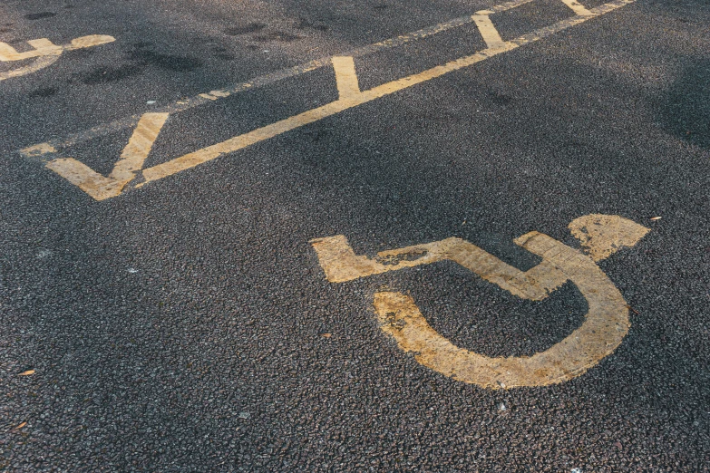a parking lot with a handicap sign painted on it, unsplash, graffiti, square, thumbnail, gold, alessio albi