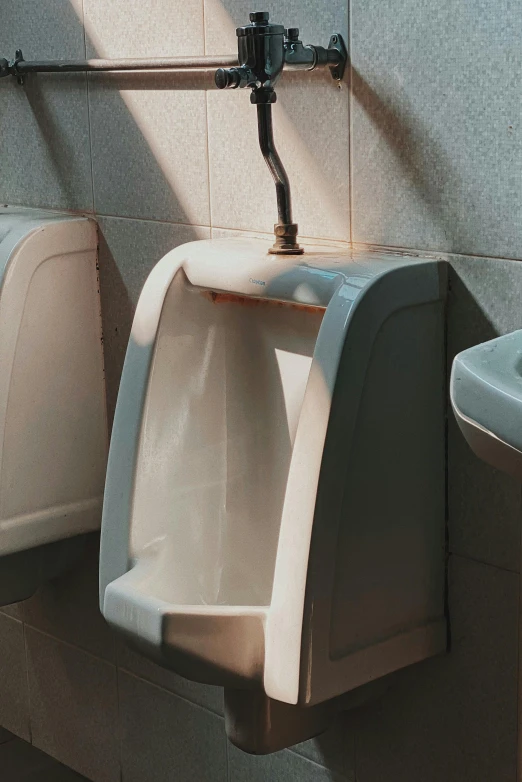 a bathroom with two urinals and a sink, by Elsa Bleda, trending on unsplash, as well as scratches, brown, thumbnail, vomit