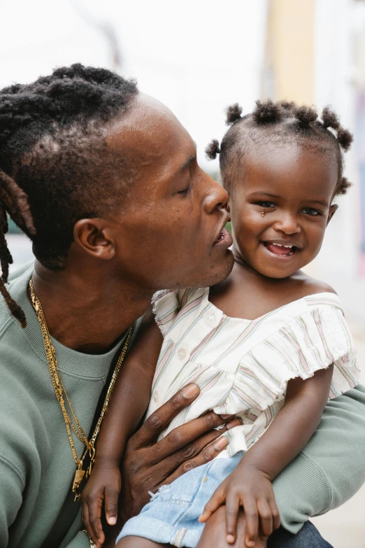 a woman kissing a little girl on the cheek, trending on unsplash, black arts movement, beautiful man, slide show, shaven, peter hurley