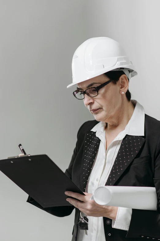 a woman in a hard hat holding a clipboard, pexels contest winner, renaissance, non-binary, ceo, ute osterwalder, on grey background