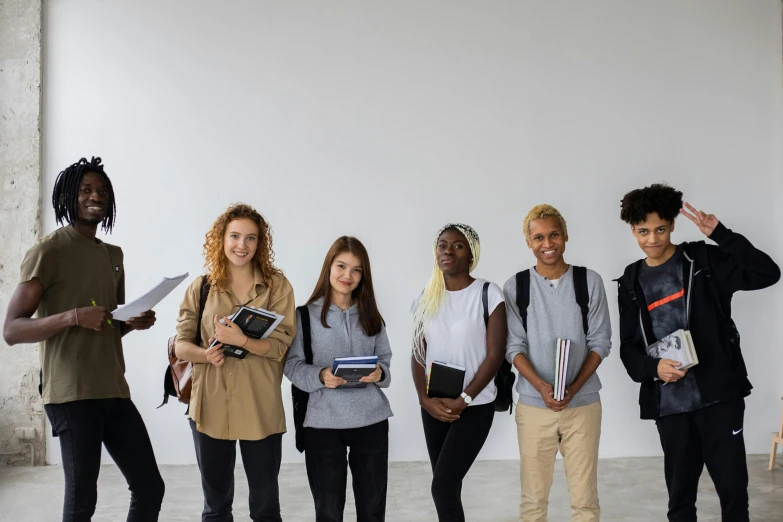a group of people standing next to each other, trending on pexels, renaissance, schools, background image, black teenage boy, holding books