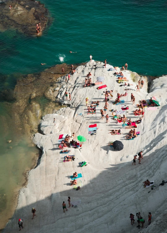 a group of people standing on top of a sandy beach, by Giorgio De Vincenzi, pexels contest winner, renaissance, over a chalk cliff, summer swimming party, “ aerial view of a mountain, white