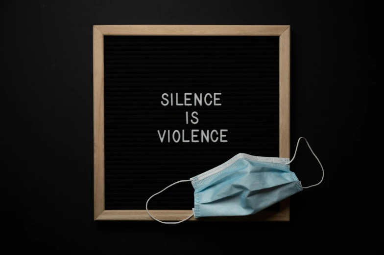 a mask on top of a sign that says silence is violence, a picture, on a dark background, background image, medicine, 1 6 x 1 6