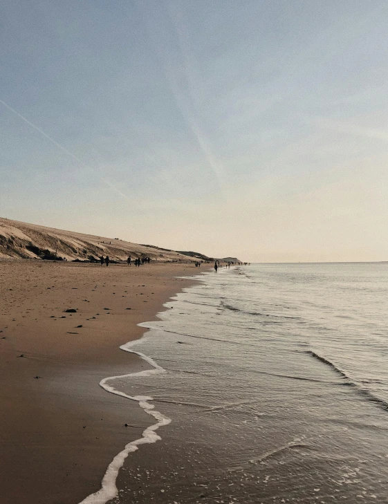 a person riding a surfboard on top of a sandy beach, body of water, dunes, at the sea, profile image