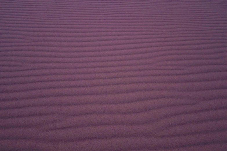 a close up of sand with a sky in the background, an album cover, inspired by Scarlett Hooft Graafland, unsplash, land art, more dark purple color scheme, magenta, subtle pattern, photo taken on fujifilm superia