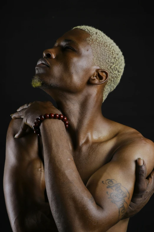 a man with a tattoo on his arm, an album cover, inspired by Candido Bido, pexels, beautiful male drow, from kehinde wiley, platinum blond, thin young male