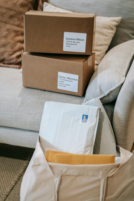 a pile of boxes sitting on top of a couch, letters, postage, designer product, indoor scene