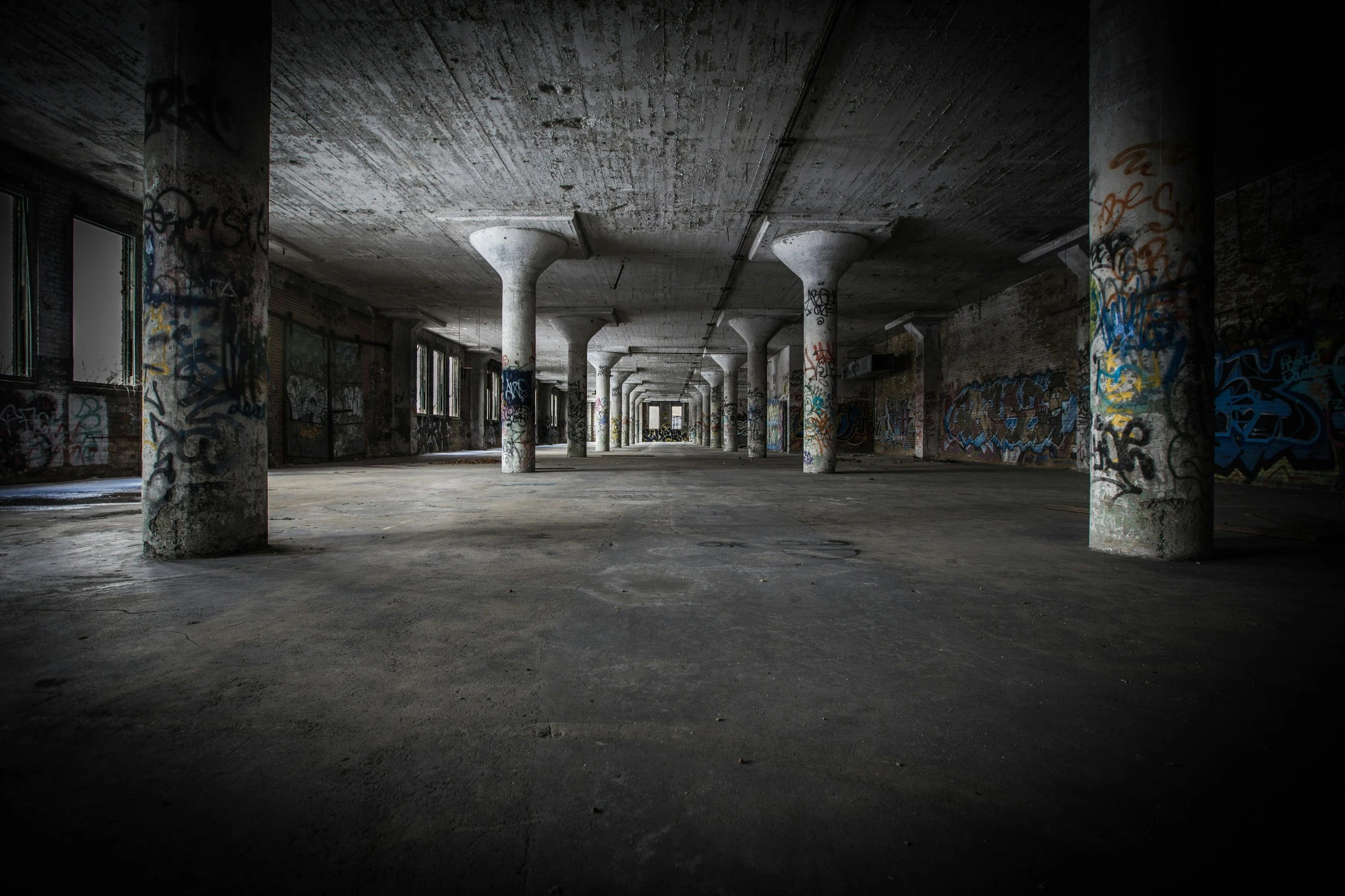 an empty building with graffiti all over it, unsplash contest winner, fallen columns, secret underground lab, ignant, military buildings