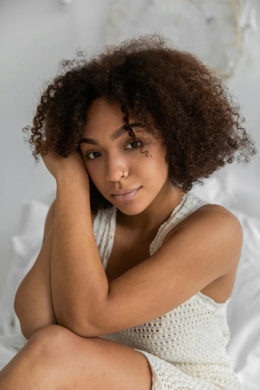 a beautiful young woman sitting on top of a bed, by Cosmo Alexander, trending on pexels, renaissance, natural hair, soft oval face, mixed race, embracing