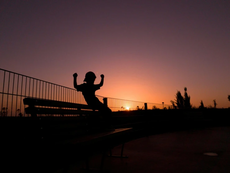 a man riding a skateboard up the side of a ramp, by Niko Henrichon, pexels contest winner, happening, sunset halo behind her head, sitting on a park bench, fists in the air, sittin