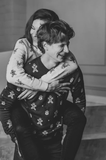 a man carrying a woman in his arms, a black and white photo, by Emma Andijewska, pexels, wearing pajamas, wearing festive clothing, head bent back in laughter, brunette boy and redhead boy