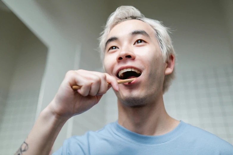 a man brushing his teeth with a toothbrush, inspired by Tooth Wu, pexels contest winner, hyperrealism, ginko showing a new mushi, gold teeth, xqc, no - text no - logo