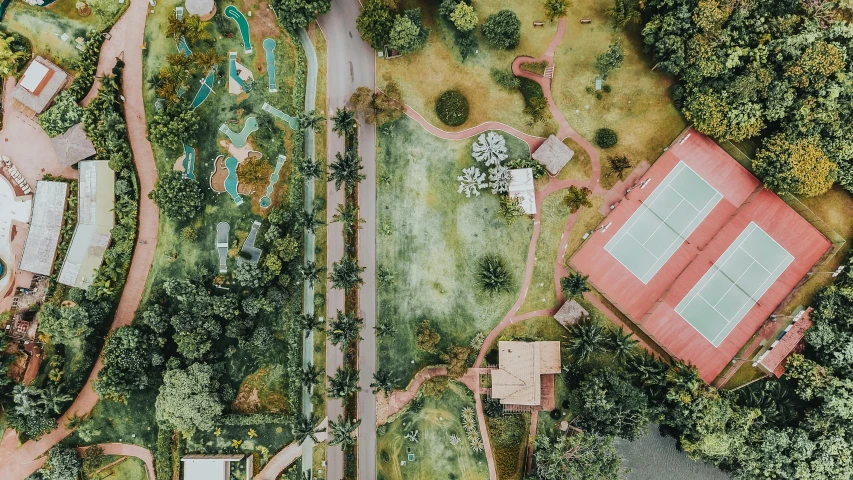 an aerial view of a tennis court surrounded by trees, by Daniel Lieske, pexels contest winner, realism, above lush garden and hot spring, in a tropical and dystopic city, lawns, landscape photo-imagery