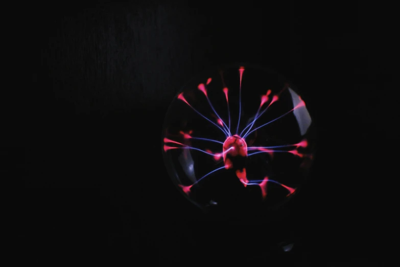 a plasma ball in the dark, by Adam Marczyński, pexels, radiolaria, pink light, newton's cradle, inside a marble