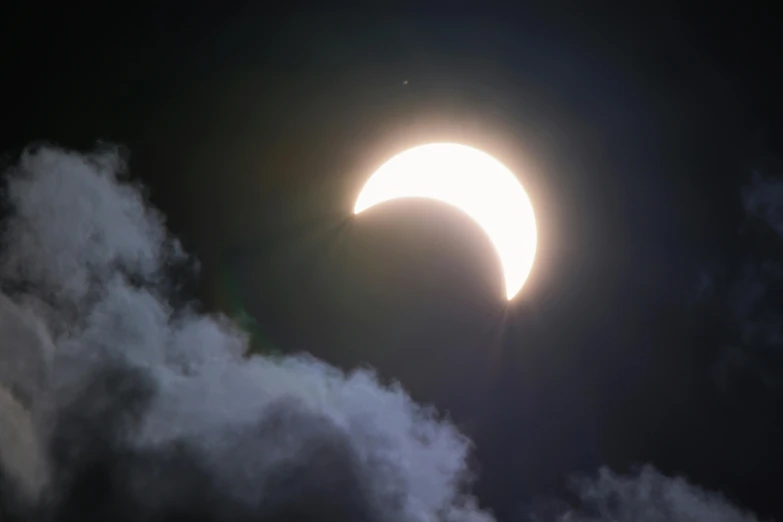 a partial solar eclipse with clouds in the foreground, an album cover, trending on unsplash, ☁🌪🌙👩🏾, earth seen on the dark sky, solar sails, moonlight showing injuries