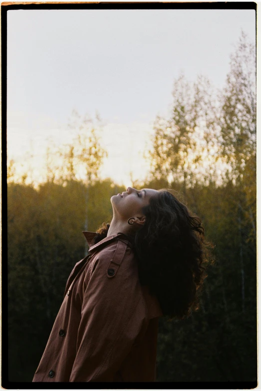 a woman is looking up at the sky, by Attila Meszlenyi, happening, sunny amber morning light, scanned, turning her head and smiling, alexey gurylev