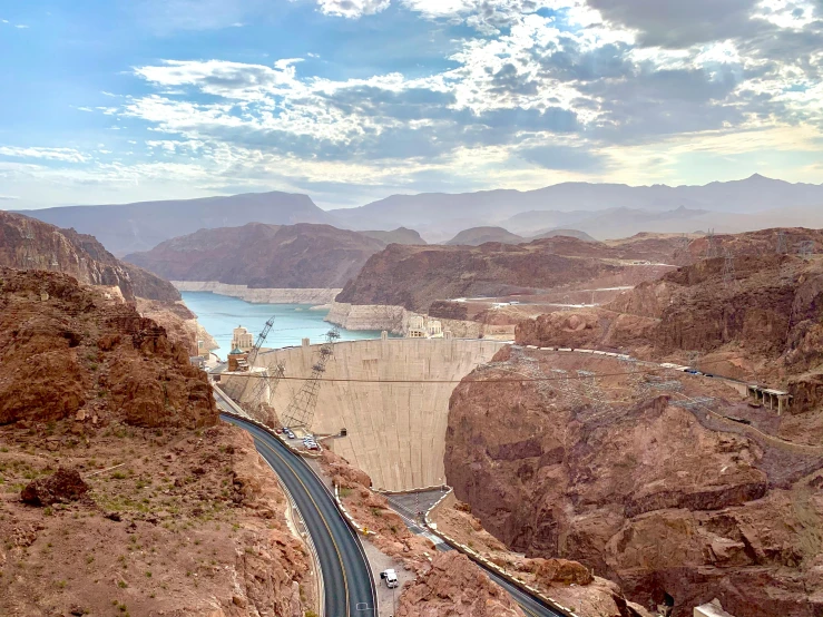 a road going through a canyon next to a body of water, las vegas, water and power, brown, slide show