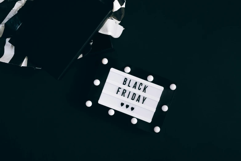 a black friday sign sitting on top of a black table, by Julia Pishtar, pexels contest winner, hurufiyya, white with black spots, holiday vibe, white box, avatar image