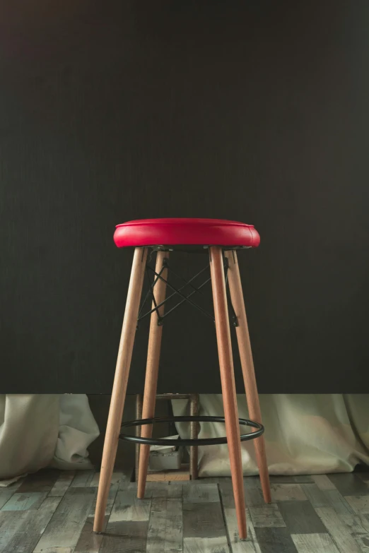 a red stool sitting on top of a wooden floor, a portrait, by James Morris, unsplash, hyperrealism, vivid studio light, medium, kek, tall