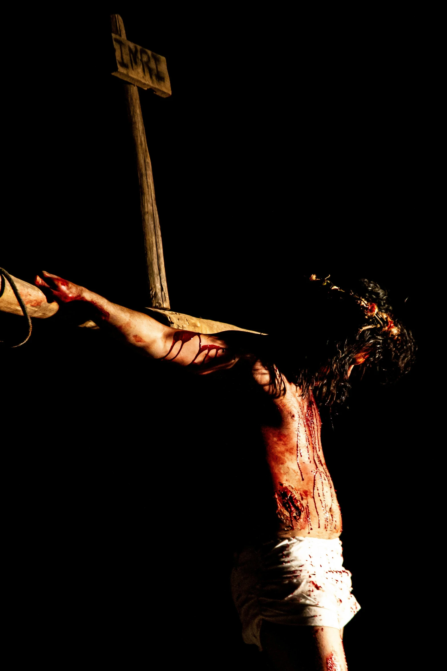 a close up of a person on a cross, by Jan Tengnagel, pexels contest winner, hurufiyya, [ theatrical ], bloody scene, hanging, 2 0 0 4 photograph