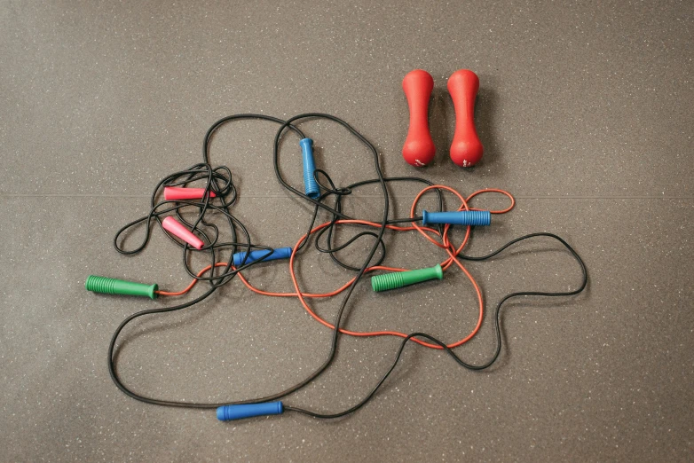 a bunch of wires sitting on top of a floor, fitness, blue or red, 165 cm tall, rubbery