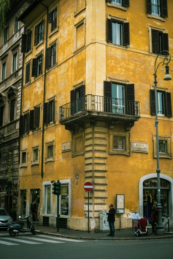 a tall yellow building sitting on the side of a street, inspired by Carlo Maderna, neoclassicism, old color photograph, rome, a quaint, brown