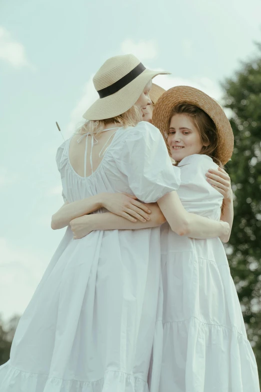 two women in white dresses hugging each other, pexels contest winner, with hat, vintage aesthetic, midsommar - t, ( ( theatrical ) )