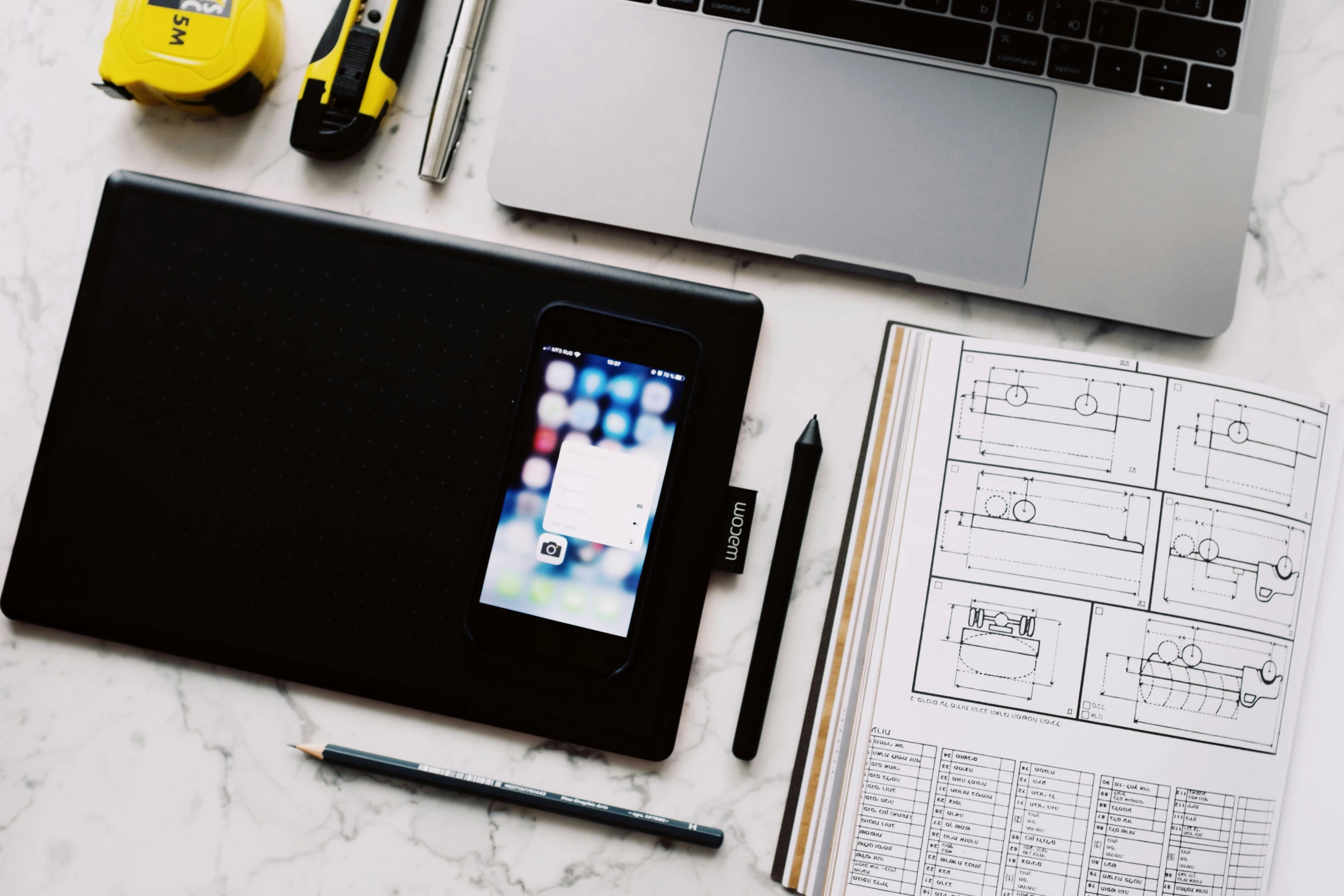 a laptop computer sitting on top of a desk next to a notebook, a picture, by Glennray Tutor, pexels contest winner, draw with wacom tablet, scanning items with smartphone, architect, dwell