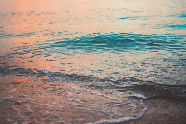 a close up of a body of water near a beach, a picture, inspired by Elsa Bleda, unsplash, pink and teal and orange, calm evening, currents, sandy colours