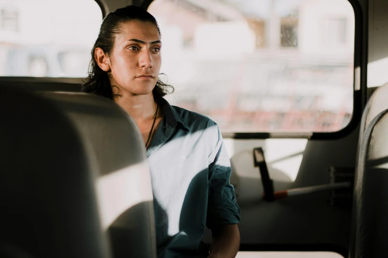 a woman sitting in the back seat of a bus, a portrait, pexels contest winner, renaissance, young greek man, mid long hair, lean man with light tan skin, lachlan bailey