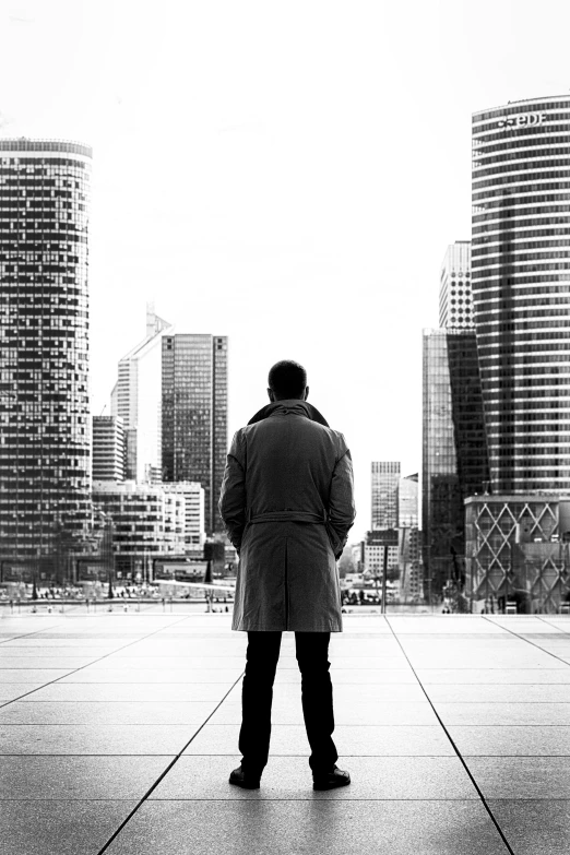 a black and white photo of a man standing in front of a cityscape, inspired by Pierre Pellegrini, in roger deakins style, :: morning, stockphoto, white collar