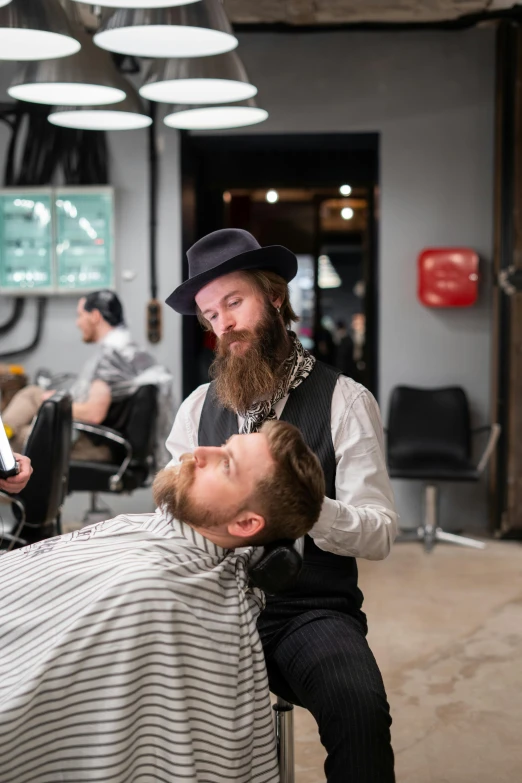 a man getting a haircut at a barber shop, alex grey and dan hillier, brown beard, lachlan bailey, colour photo