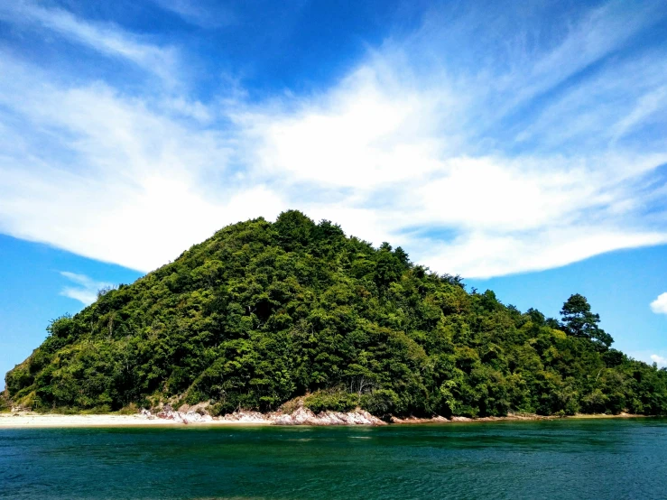 a small island in the middle of a body of water, by Bascove, pexels contest winner, sumatraism, abel tasman, hill with trees, thumbnail, slide show