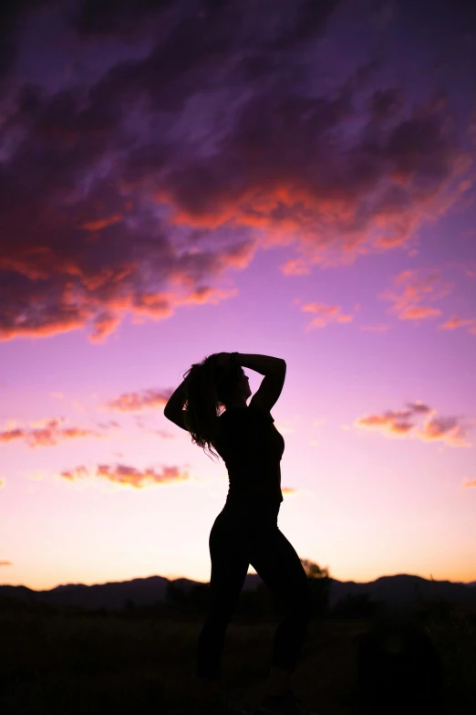 a silhouette of a woman standing in a field at sunset, by Gwen Barnard, pexels contest winner, arabesque, macho pose, girl clouds, death valley, fit curvy physique