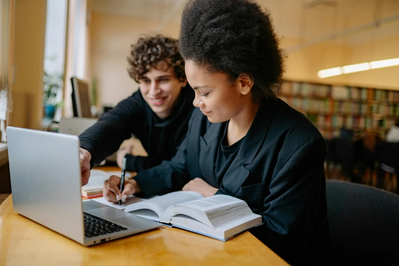 a couple of people sitting at a table with a laptop, pexels contest winner, academic art, black, school curriculum expert, library books, instagram post