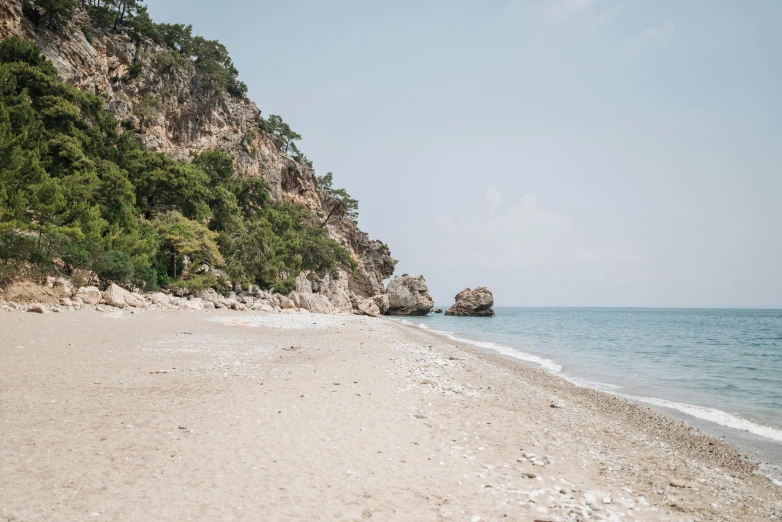 a sandy beach with a mountain in the background, unsplash, les nabis, mount olympus, 2000s photo, coastal cliffs, turkey