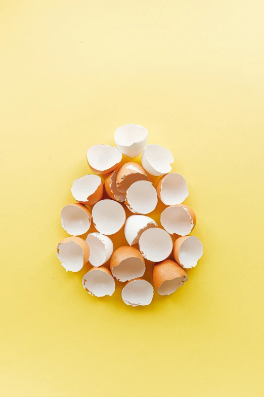 a pile of eggs sitting on top of a yellow surface, torn paper edges, white ceramic shapes, lpoty, profile image