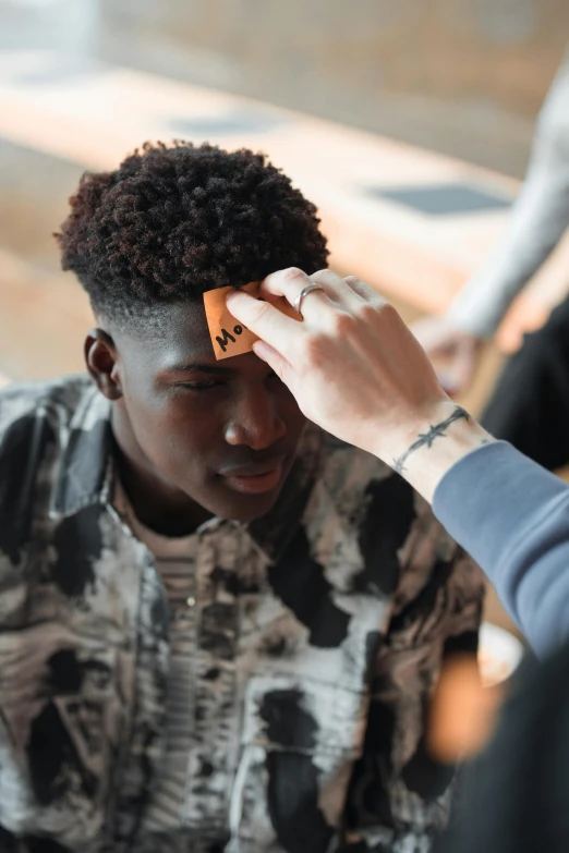 a man getting his hair cut at a barber shop, trending on pexels, black teenage boy, wearing a patch over one eye, brainstorm, with grey skin