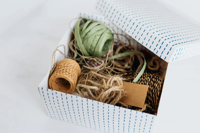 a box filled with twine of twine and twine of twine, by Eden Box, pexels contest winner, arts and crafts movement, paper decoration, wide ribbons, product introduction photo, thumbnail