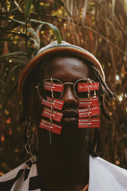 a man with a pair of glasses on his face, an album cover, inspired by Ras Akyem, trending on pexels, afrofuturism, chief keef in the garden of eden, earbuds jewelry, yasuke 5 0 0 px models, gold and red metal