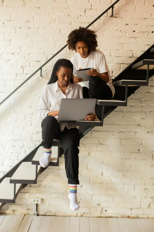 two women sitting on stairs using laptops, trending on pexels, black arts movement, small steps leading down, realistic », dwell, mechanics