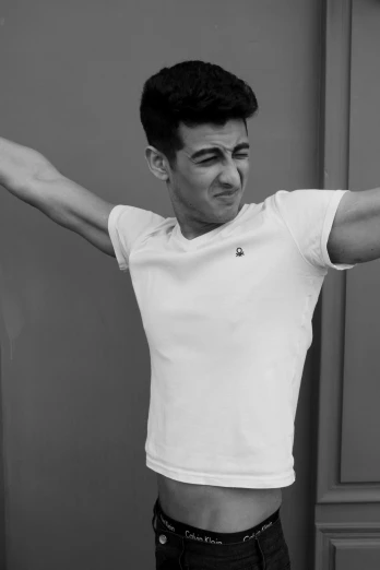a black and white photo of a man with his arms outstretched, inspired by Ludovit Fulla, zayn malik, wearing white shirt, mark edward fischbach, armpit