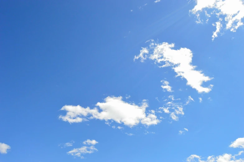 a man flying a kite on top of a lush green field, unsplash, minimalism, tall fluffy clouds, light blues, midday photograph, nintendo clouds