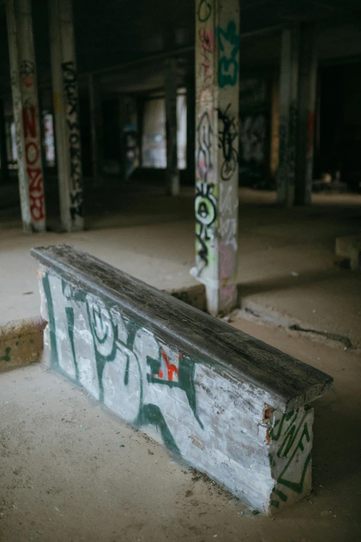 a man riding a skateboard up the side of a ramp, unsplash, graffiti, in an abandoned barn, benches, camo, a 35mm photo