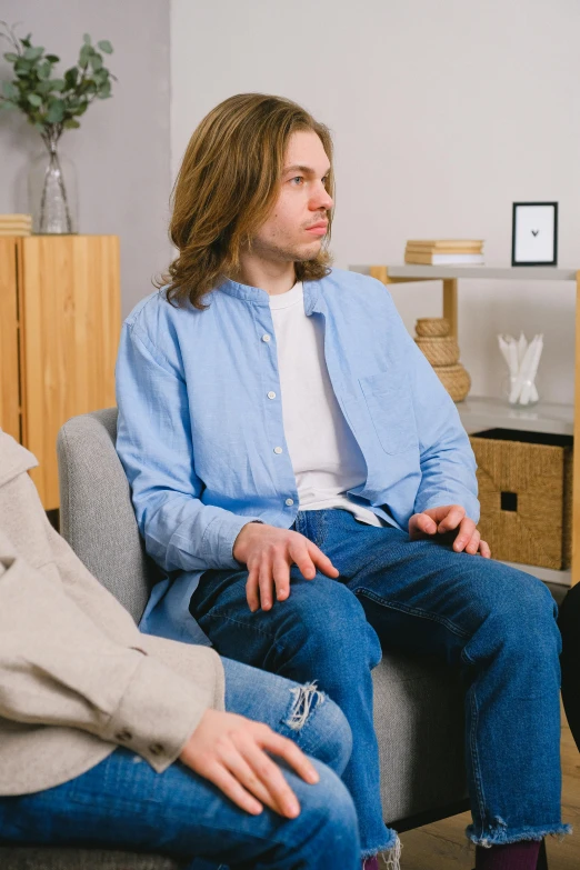 a group of people sitting on top of a couch, sad man, colour corrected, sitting cross-legged, realistic »